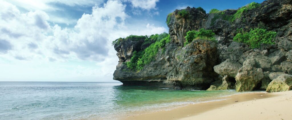 En bild på en strand med klippor
